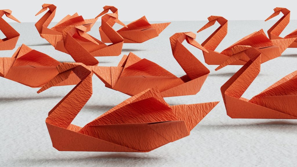 a group of orange origami swans sitting on top of a table